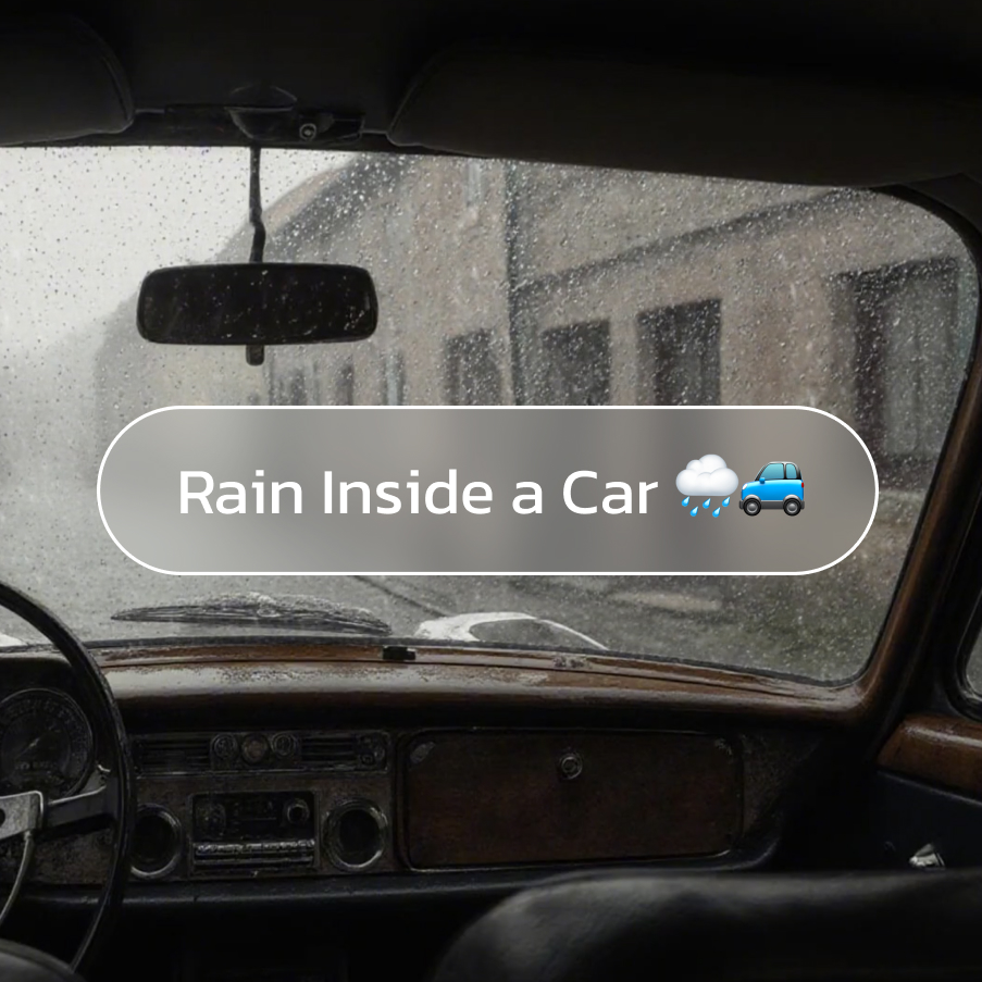 View from inside a parked car with rain falling on windows, creating a cozy and enclosed rain ambience.